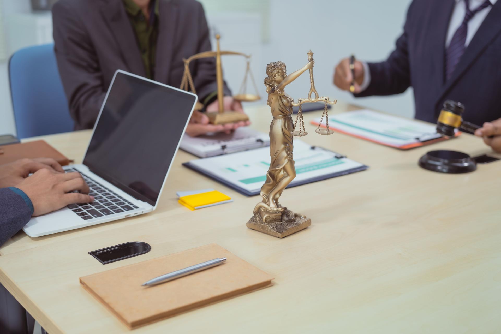 Three lawyers in a meeting at the table in an office, discussing business, civil and commercial law, labor law, marketing and advertising law,offering legal consulting and case management services.