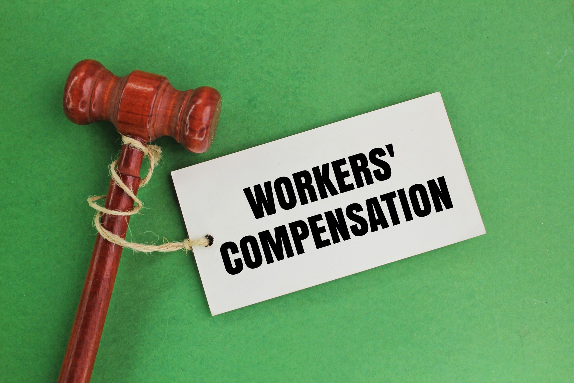 judge's hammer and a paper tag with the words workers' compensation. provides protection to employees of the Insured against any injury.